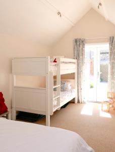 East RudhamBakers Court的卧室配有白色双层床和窗户。
