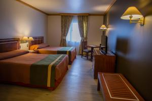 蒙特港圣地亚哥德阿尔马格罗蒙特港酒店的酒店客房设有两张床和一张桌子。