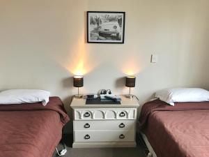 杰拉尔丁Geraldine Heritage Hotel的一间卧室配有两张床和一个带梳妆台的白色梳妆台。