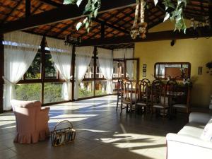特雷索波利斯Pousada Jardim Comary的客厅配有桌椅和窗户。