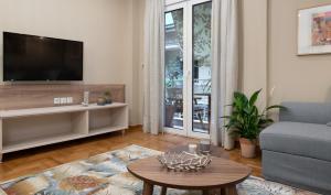 雅典Absolute Athens IV的客厅配有电视、沙发和桌子