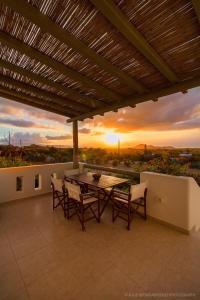 纳克索乔拉Aerides Villas的一个带桌椅的庭院,享有日落美景。