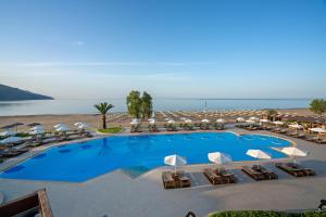 耶奥伊乌波利斯派洛特滨海度假酒店的享有带椅子和遮阳伞的度假村的游泳池景致