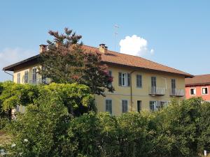 阿斯蒂Locanda Ferro UNO, Golf Città di Asti的前面有树木的黄色建筑