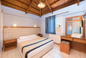 米蒂利尼鸡血石公寓酒店的一间卧室设有一张大床和一个窗户。
