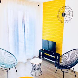 维勒班特BtoBed - 巴黎北维勒班特公寓的客厅配有两把椅子和电视