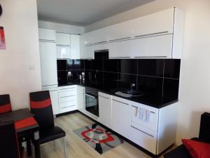 奥古斯图Wygoda的厨房配有白色橱柜和黑色台面
