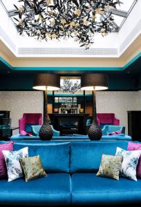 日内瓦蒂凡尼酒店的客厅配有带枕头的蓝色沙发