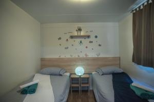 耶泽拉Mobile Homes SEA JOY的一间卧室配有两张床和一张带台灯的桌子