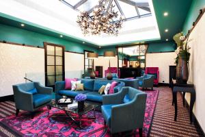 日内瓦蒂凡尼酒店的大堂设有蓝色的沙发、椅子和吊灯