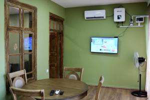 迪利然Dilijan Town Inn的一间设有桌子和墙上电视的用餐室