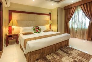 阿哈达Al Muhaidb Al Hada Resort的一间卧室配有一张大床,床上插着花朵