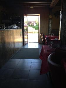 Fauverney福韦尔内旅馆的餐厅设有红色的桌子和通往庭院的门