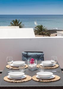 宏达海滩Luxury Beach Apartments的桌子,上面有盘子和玻璃杯,还有海洋