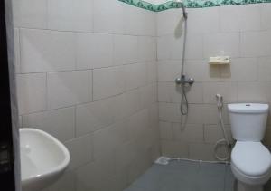 沙努尔欧文客房旅馆的带淋浴、卫生间和盥洗盆的浴室