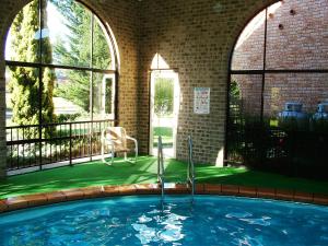 潘布拉Idlewilde Town & Country Motor Inn的一座带大窗户的建筑中的游泳池