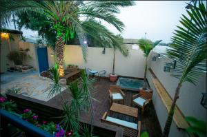 贝尔谢巴Eshel Mansion - Boutique Suites的阳台设有一座带游泳池和棕榈树的庭院。