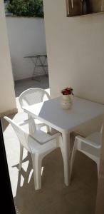 阿韦特拉纳Le 5 Volte的白色的桌子和椅子,上面有花瓶
