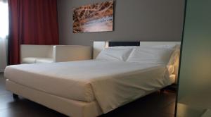 基耶蒂贝斯特韦斯特帕可帕格里亚酒店的卧室配有一张白色大床和一把椅子