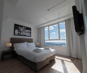 特拉维夫Sea view apartment suite的一间卧室设有一张大床和一个大窗户