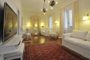 阿尔盖罗拉斯多洛娜斯温泉别墅酒店的客厅配有白色沙发和电视