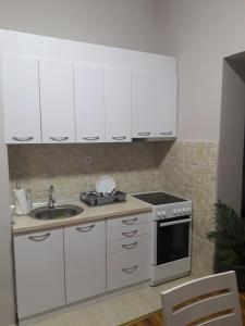 弗拉涅Stankovic Apartman的厨房配有白色橱柜、水槽和炉灶。