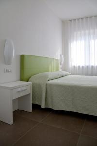 托尔博莱Casa Rosa dei Venti的一间卧室设有两张床、一张桌子和一个窗口