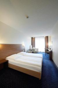 赫尔-格伦茨豪森斯里斯恩酒店的酒店客房设有一张大床和一张书桌。