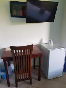 Matoury马尔莫特酒店的一张带椅子的小桌子和一台小冰箱