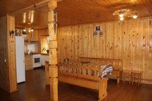 米库利钦Cottage Milena的厨房设有木墙、桌子和冰箱。