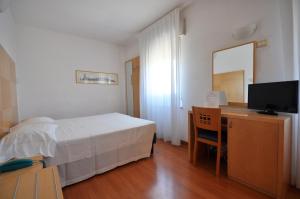 帕多瓦伊赫亚酒店的一间卧室配有一张床和一张书桌及电视