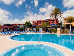 梅罗那瑞斯Villa Feliz 128的一座带椅子的度假村的游泳池和一座建筑