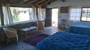 罗恰拉塔霍纳农家乐的卧室配有一张床和一张桌子及椅子