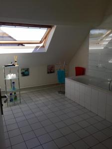 Tillé奥德酒店的阁楼浴室配有浴缸和天窗。