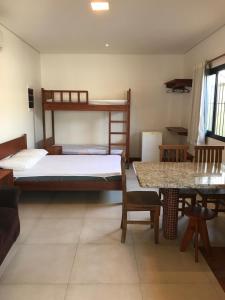 乌巴图巴Suites Grande Tenorio的客房设有两张双层床和一张桌子。