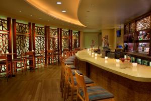 波士顿Seaport Hotel® Boston的餐厅内带木椅和柜台的酒吧