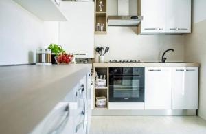 穆拉诺casa dei nonni的厨房配有白色橱柜和烤箱。