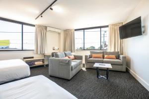 布里斯班查尔顿科纳奈特卡普酒店的一间酒店客房,配有沙发床和电视