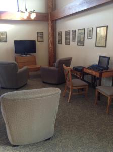 西沃德微风汽车旅馆的客厅配有电视、椅子和桌子