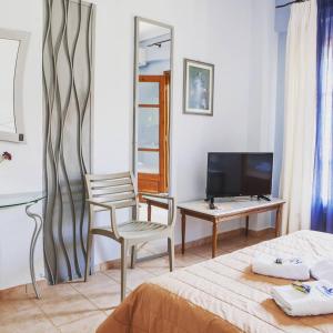 阿莫利亚尼岛卡斯塔利亚公寓式酒店的一间卧室配有一张床、一把椅子和电视