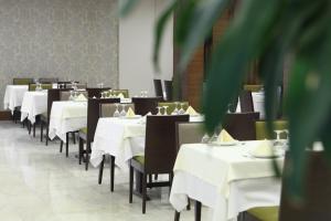 安卡拉耶幼砵姆酒店的用餐室配有白色桌子和黑色椅子