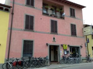 基安蒂格雷夫盖罗洛肯达酒店Il的一座粉红色的建筑,前面停放着自行车