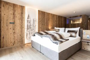 库龙韦诺斯塔Aktiv- und Wellnesshotel Traube- Post的卧室配有一张白色大床和木墙