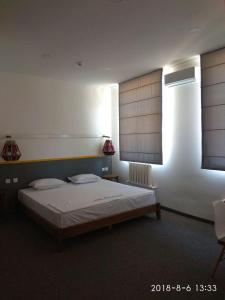 撒马尔罕Art Samarqand的一间卧室配有一张床和一个带百叶窗的窗户
