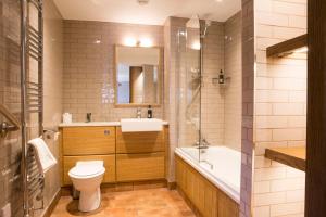 特劳特贝克王后之首酒店的浴室配有卫生间、盥洗盆和浴缸。