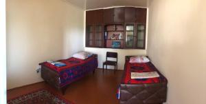 舍基Shaki Host House的一间设有两张床和椅子的房间