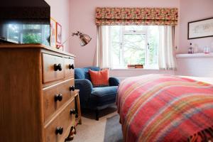 库克姆Bel and The Dragon-Cookham的一间卧室配有梳妆台、一张床和椅子