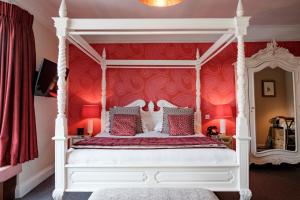 布里德波特布尔酒店的卧室配有白色的天蓬床和红色的墙壁