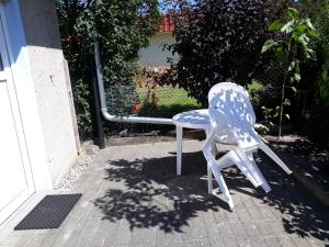 卡尔斯哈根Ferienzimmer Schwalbennest的坐在房子外的蓝白椅子
