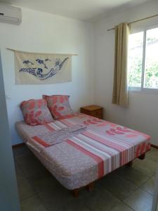 阿瓦托鲁Farehani 2的一间卧室配有一张带条纹毯子的床和窗户